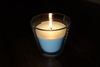 A blue candle lit in a darkened room